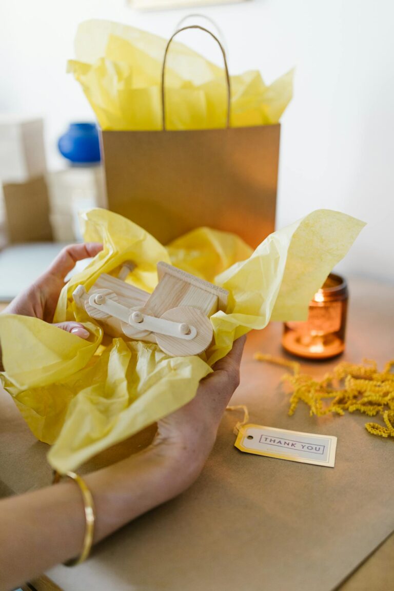 Close-up of hands preparing a gift with a wooden toy and thank you tag, vibrant and inviting.